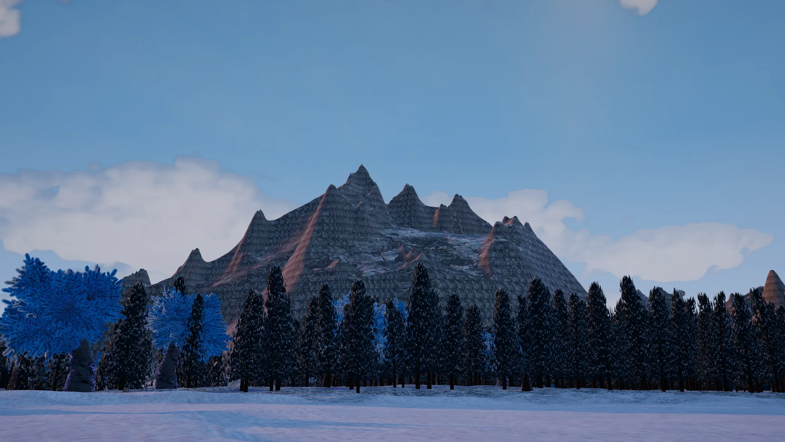 A jagged snowy mountain behind a line of pine trees.